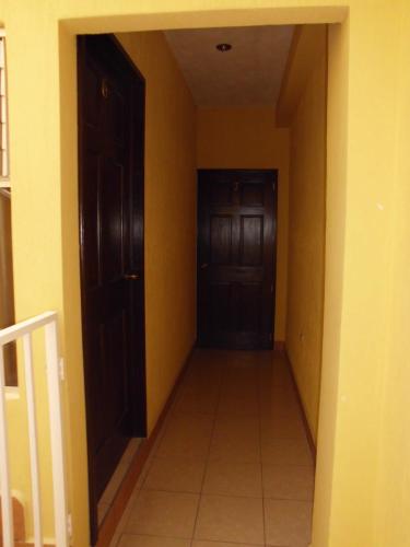 an empty hallway with two brown doors and a tile floor at Crysol Center Hotel in Chimaltenango