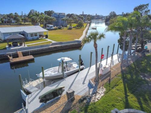 a boat is docked at a dock in the water at Hernando Hideaway:Heated Pool/Decks/Dock/Balcony/Yard w/ Firepit/Kayaks in Hernando Beach