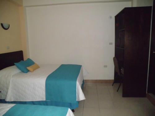 a bedroom with a bed and a dresser in it at Crysol Center Hotel in Chimaltenango