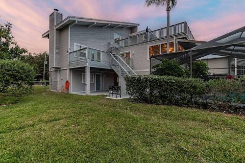 a large house with a lawn in front of it at Hernando Hideaway:Heated Pool/Decks/Dock/Balcony/Yard w/ Firepit/Kayaks in Hernando Beach