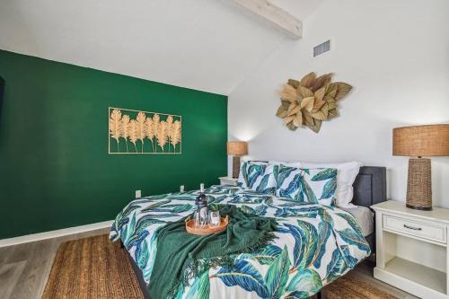 a bedroom with a bed with a green accent wall at Hernando Hideaway:Heated Pool/Decks/Dock/Balcony/Yard w/ Firepit/Kayaks in Hernando Beach