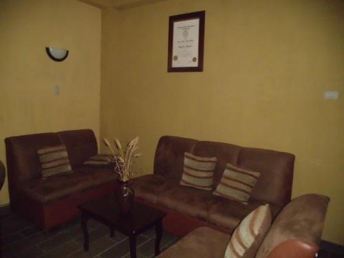 a living room with two brown couches and a table at Crysol Center Hotel in Chimaltenango