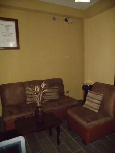 a living room with two couches and a coffee table at Crysol Center Hotel in Chimaltenango