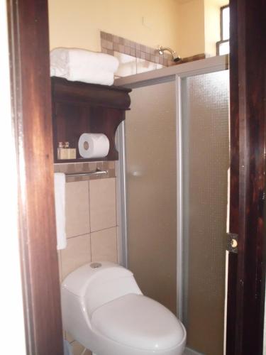 a small bathroom with a toilet and a shower at Crysol Center Hotel in Chimaltenango