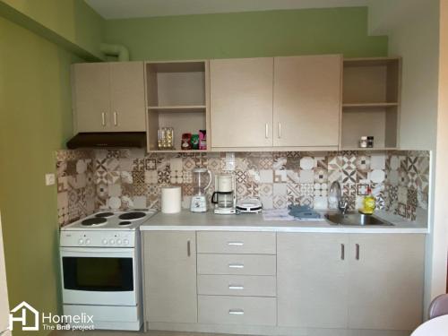 uma cozinha com armários brancos e um forno de fogão branco em Dimora em Chalkida