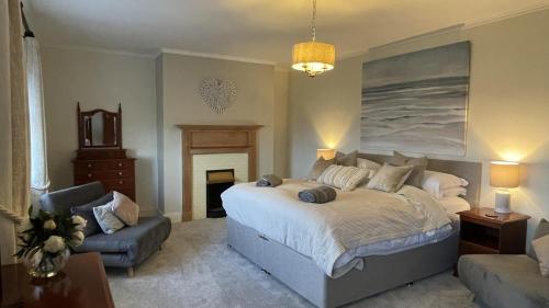 a bedroom with a large bed and a couch at Tan Y Cytiau in Holyhead
