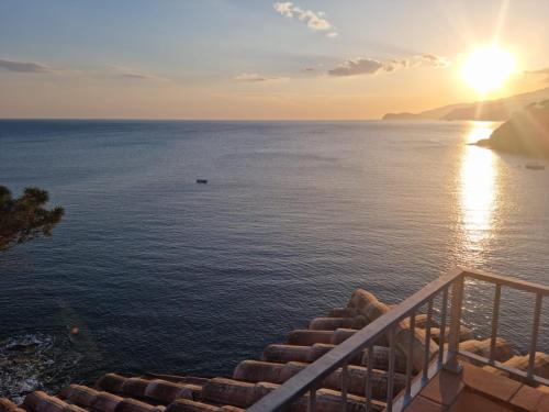 a view of the ocean at sunset from a balcony at Rosa dei Venti Est in Capoliveri