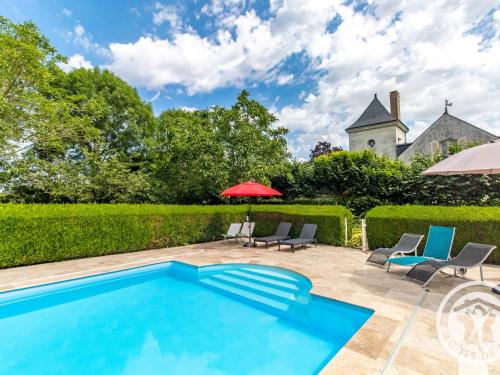 une piscine avec des chaises et un parasol ainsi qu'une maison dans l'établissement Maison de Charme avec Piscine Chauffée à 300m de la Loire, Proche Saumur et Sites UNESCO - FR-1-622-70, à La Menitré
