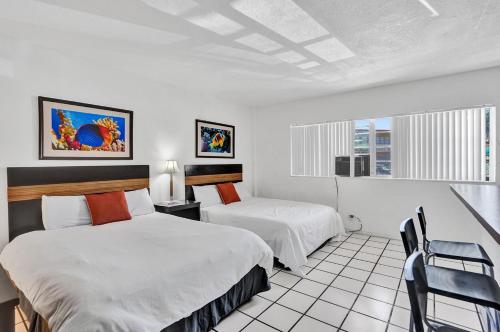 una habitación de hotel con 2 camas y una silla en Hallandale Beach Vacation Home Pool Beach, en Hallandale Beach