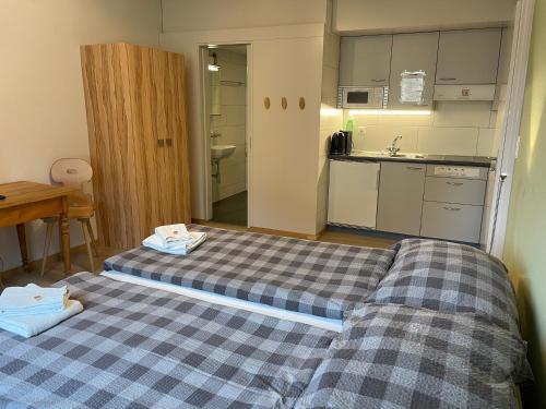 two beds in a small room with a kitchen at Interlaken Apartments in Interlaken