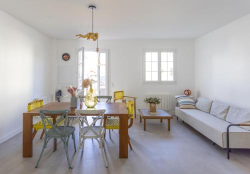 un salon avec une table et un canapé dans l'établissement VillaGigi Maison de Plage en plein cœur d'Arcachon, à Arcachon