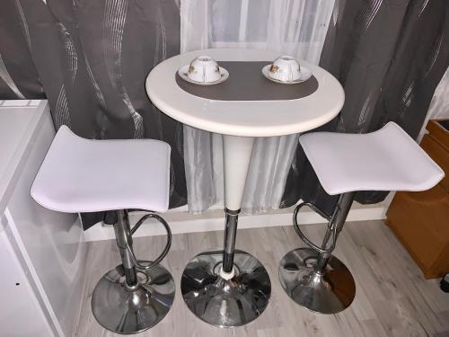 a small white table with two stools in a room at Chambre charmante entre Paris et Disney in Noisy-le-Grand