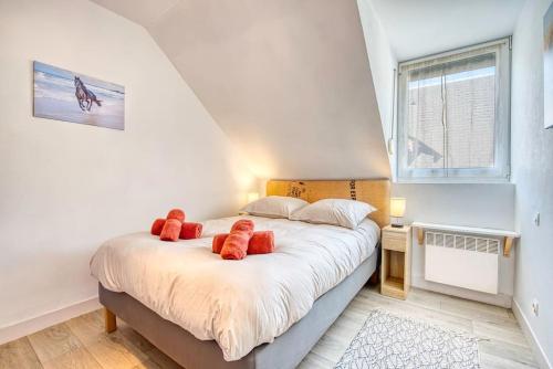 una camera da letto con un letto con cuscini rossi di Le Fer à Cheval 4 pers. Confort Plage a Houlgate