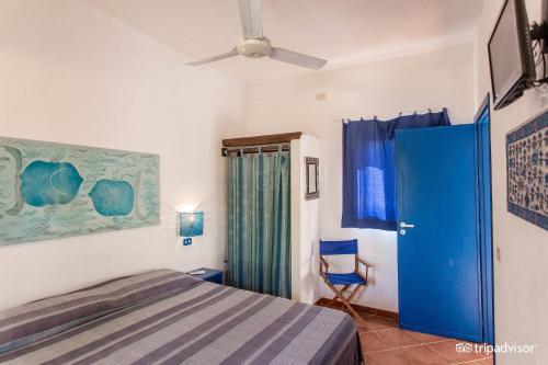 a bedroom with a bed and a blue door at B&B Cala Pisana (Paola e Melo) in Lampedusa