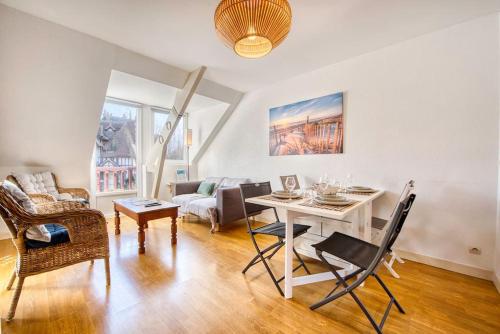 un salon avec une table et un canapé dans l'établissement Le Fer à Cheval 4 pers. Confort Plage, à Houlgate