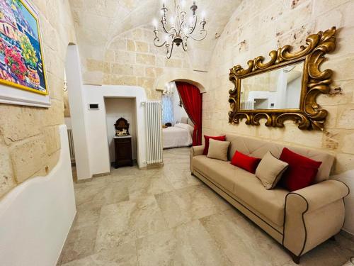 a living room with a couch and a mirror at La Carosa Suite in Oria