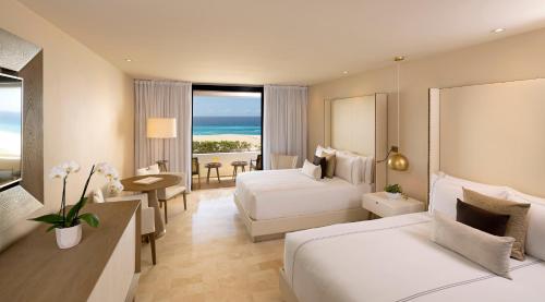 a hotel room with two beds and a view of the ocean at Paradisus Los Cabos - Adults Only - All Inclusive in Cabo San Lucas