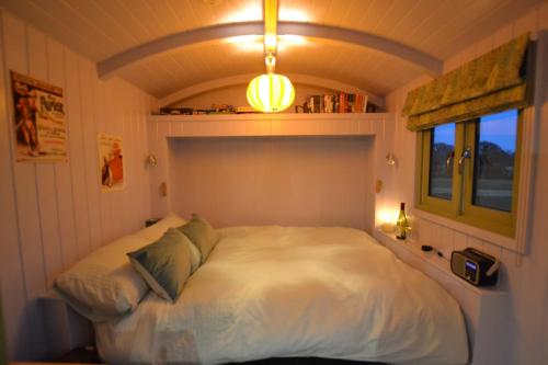 a bedroom with a white bed in a room at Twin Barn Shepherd’s Huts in Norwich