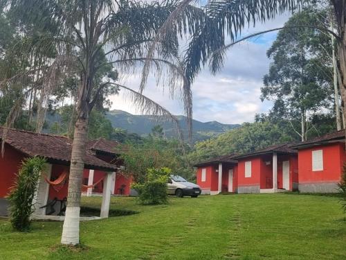 a row of red houses with a car parked in front at Pousada do Tie - Rio Preto MG in São José do Rio Preto
