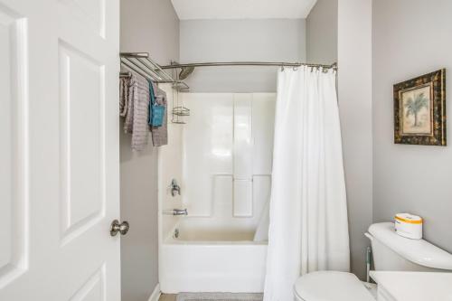 a white bathroom with a tub and a toilet at Relax at Barefoot Getaway in North Myrtle Beach! in North Myrtle Beach