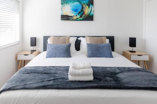 a bedroom with a large white bed with blue pillows at 2BD/2BA Apartment in DT ALhambra in Alhambra