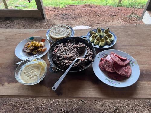 a table with plates of food on a wooden table at Finca Del Cielo in El Castillo de la Fortuna