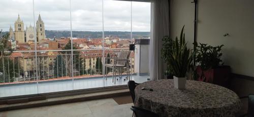 a room with a table and a view of a city at ÁTICO Pleno centro Parking in León