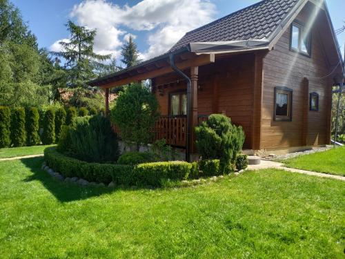 una casa di legno con un cortile di Domek letniskowy OAZA a Ryn