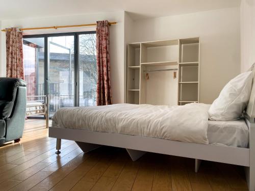 une chambre avec un grand lit et une fenêtre dans l'établissement Chambres Pasteur, à Montreuil