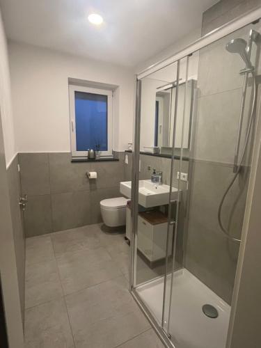 a bathroom with a shower and a toilet and a sink at Neubauwohnung mit großem Balkon in Aichtal 