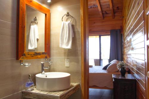 a bathroom with a sink and a bedroom with a bed at San José del Pacífico Camino al Cielo in El Pacífico