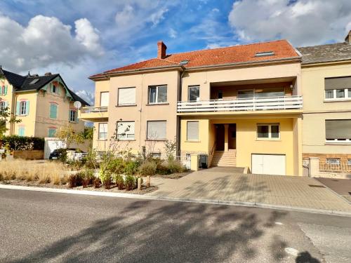 uma grande casa amarela ao lado de uma rua em La Villa du General Patton em Thionville