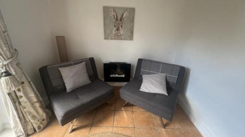 two chairs sitting in a corner of a room at Llanw Malltraeth - Malltraeth Tides in Llangadwaladr