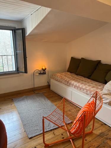 Cette chambre comprend un lit et une chaise. dans l'établissement Centre Historique Les toit du MOCO, à Montpellier