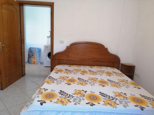 - un lit avec couverture et tournesols dans l'établissement Уютная квартира на берегу Адриатического моря, à Durrës
