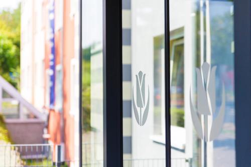 a window with a sign on the side of a building at Tulip Inn Frankfurt Airport in Neu Isenburg