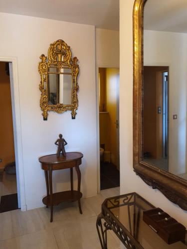 einem Spiegel an einer Wand neben einem Tisch und einem Tisch mit einem Spiegel in der Unterkunft Bastide gecko doré in Cotignac