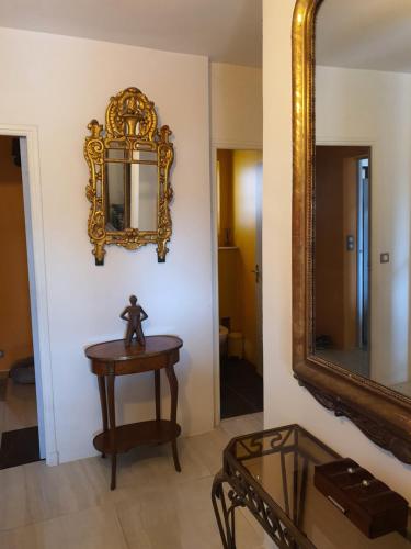 un miroir sur un mur à côté d'une table et d'une table avec un miroir dans l'établissement Bastide gecko doré, à Cotignac