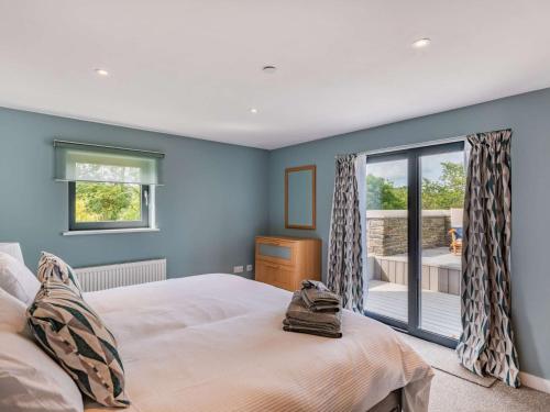 a bedroom with blue walls and a bed and a window at 2 bed in Cardigan 83919 in Cilgerran