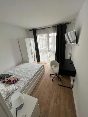 a bedroom with a bed and a desk and a window at Beautiful flat (metro 8) 10min to paris city center in Maisons-Alfort