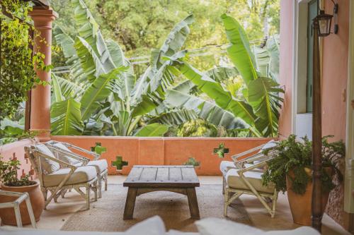 a patio with chairs and a table and plants at Casa Del Val- Villa Maria in San Bernardino