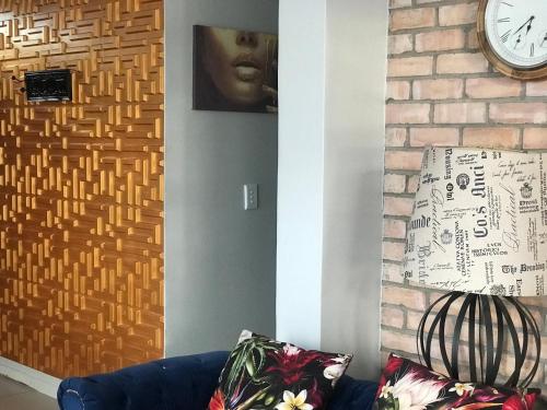 a living room with a couch and a clock on a wall at DEE-LOFT 53 in Windhoek