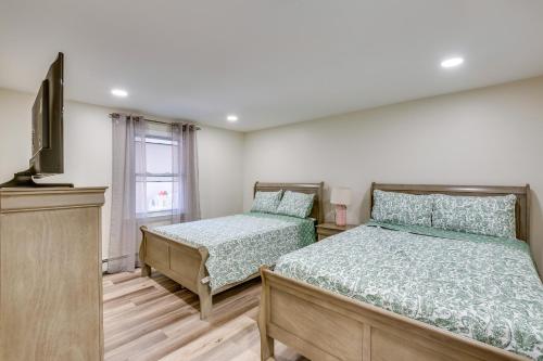 a bedroom with two beds and a flat screen tv at Central Newark Apartment 1 Mi to Downtown! in Newark