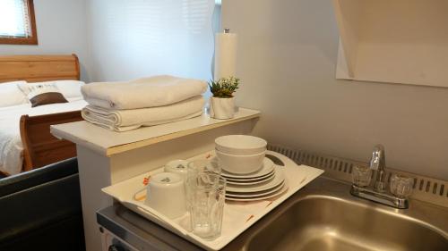 a kitchen sink with a tray with dishes on it at Caruso's Accommodation in Jasper