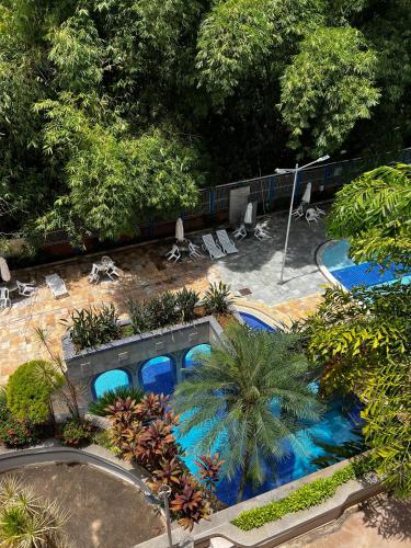 カルダス・ノバスにあるApartamento Caldas Novas Thermasの椅子と木々のあるプールの景色を見渡せます。