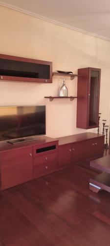 a kitchen with wooden cabinets and a microwave at Place 2 Be in Nafpaktos
