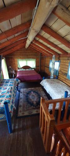 a bedroom with two beds in a log cabin at CABAÑA ABRA ANCHA in Aluminé