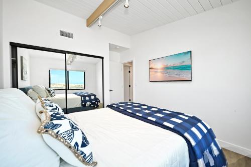 Un dormitorio con una cama blanca con almohadas azules y blancas en Immaculate Home with 180 degree views of the Beach & Ocean, en Newport Beach