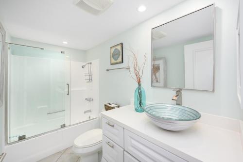een witte badkamer met een wastafel en een toilet bij 2 Bedroom Oceanfront with Patio on the Boardwalk in Newport Beach