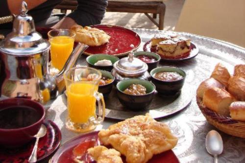 una mesa cubierta con platos de desayuno y zumo de naranja en RIaD DRISSIA Panoramic en Fez